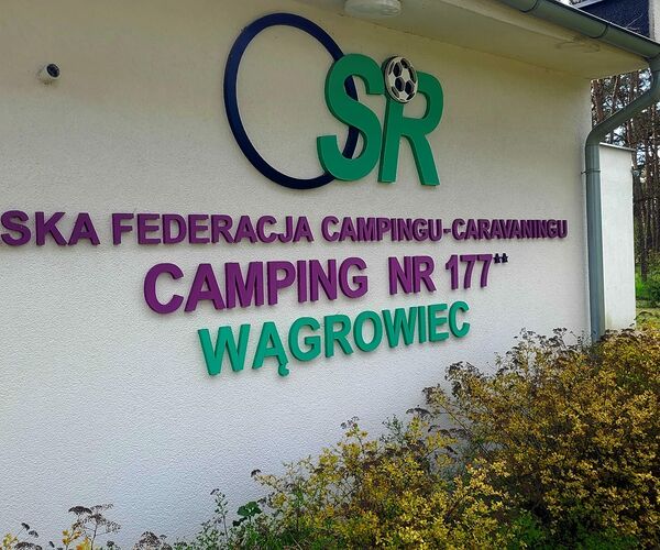 Budynek z nazwą campingu i logo ośrodka na terenie pole Camping 177